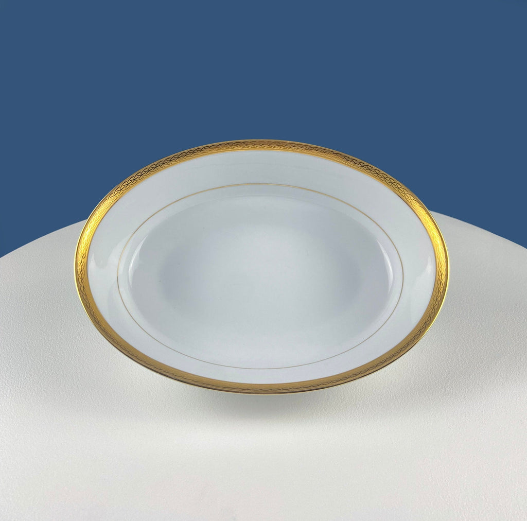 White porcelain oval serving bowl with gold rim, top view
