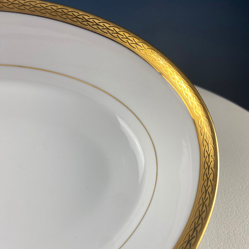 Porcelain bowl rim close-up with gold embossed pattern and thin gold stripe