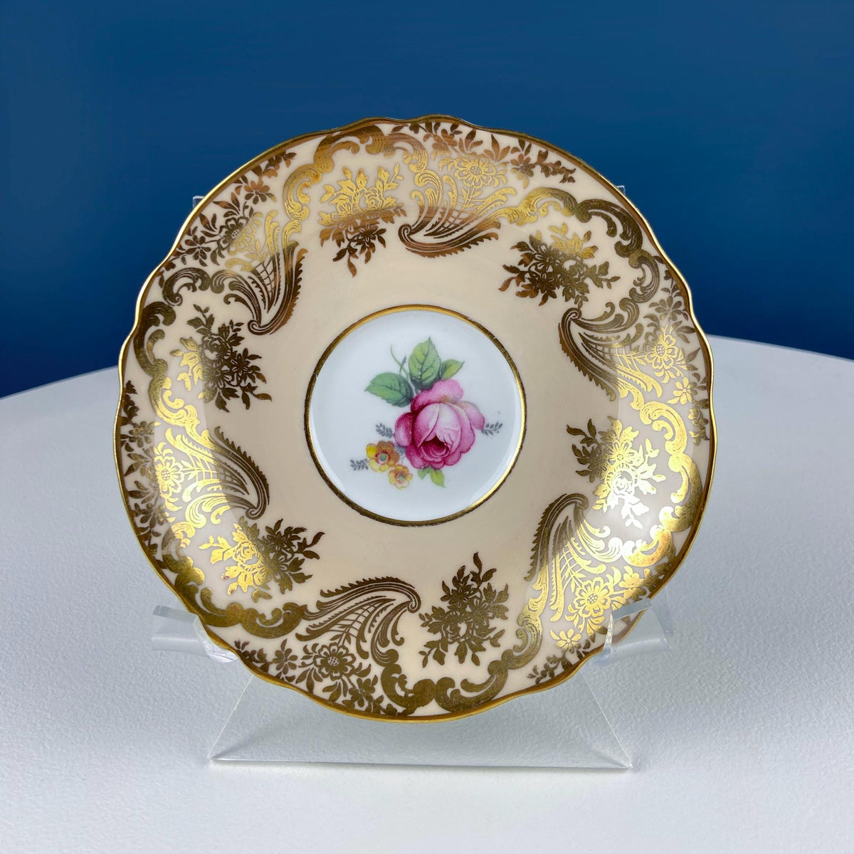 Decorative saucer with pink rose center and ornate gold floral scroll border