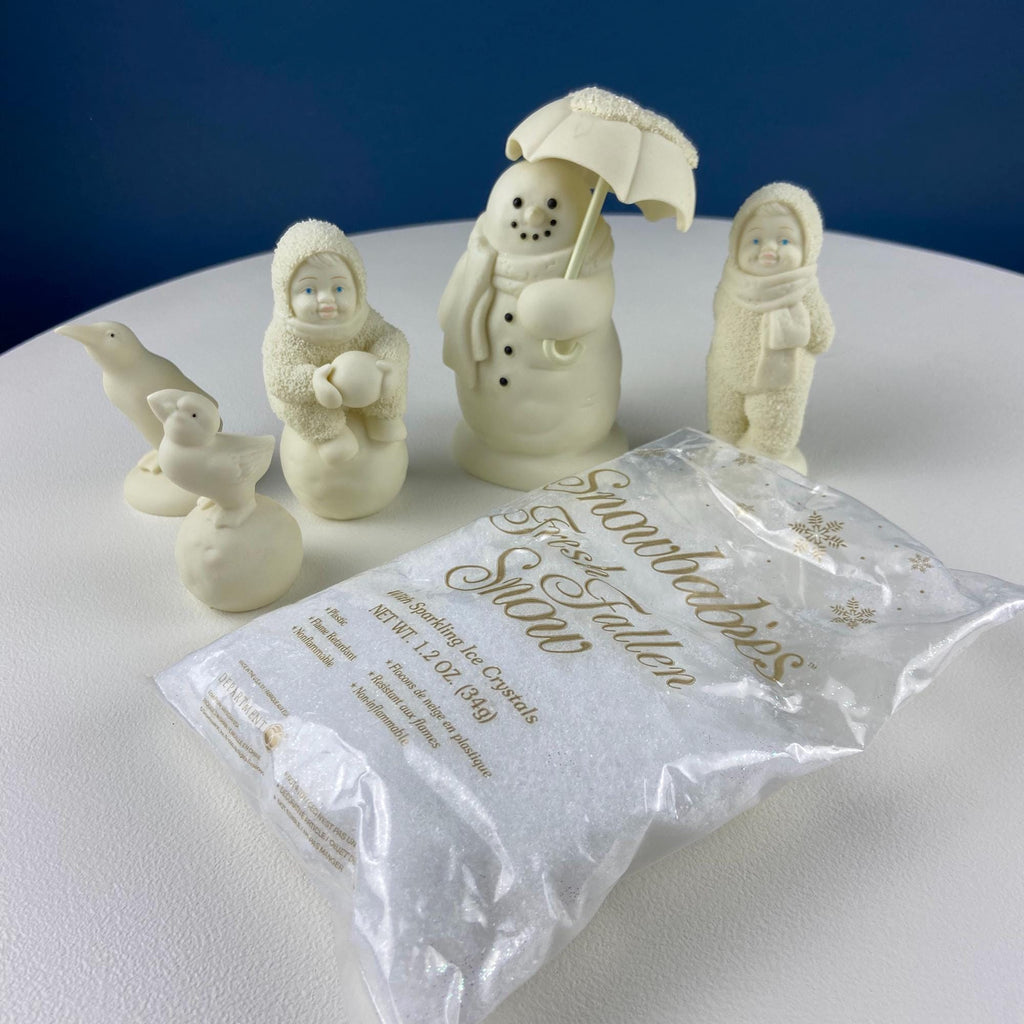 White porcelain snowman figurine with umbrella, kids and birds on snowy base
