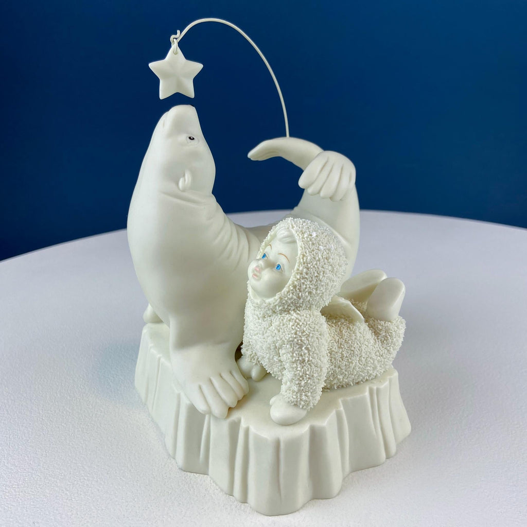 White porcelain figurine with snowbaby holding a star on a string