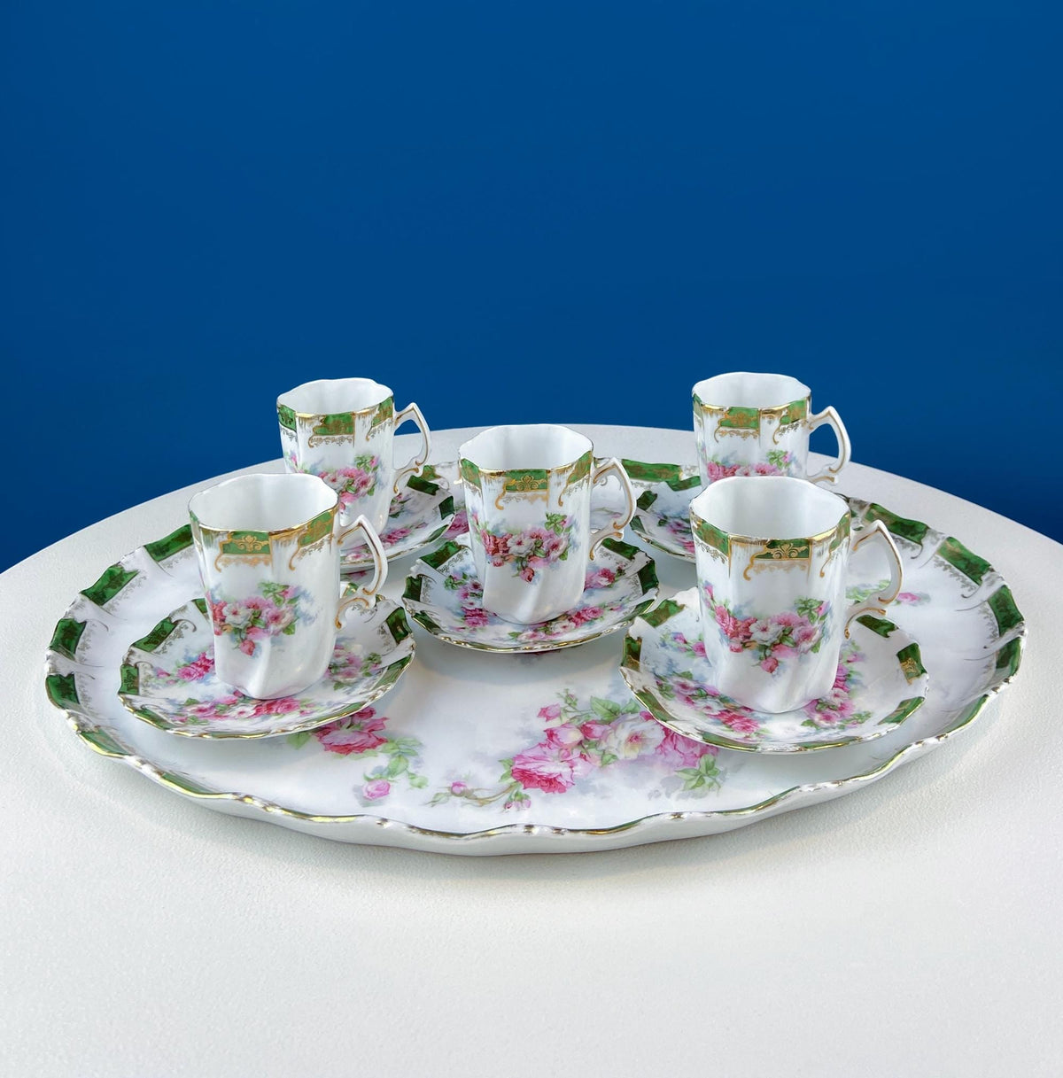 Porcelain hot chocolate set: oval tray holding five cups with hand-painted pink rose detail