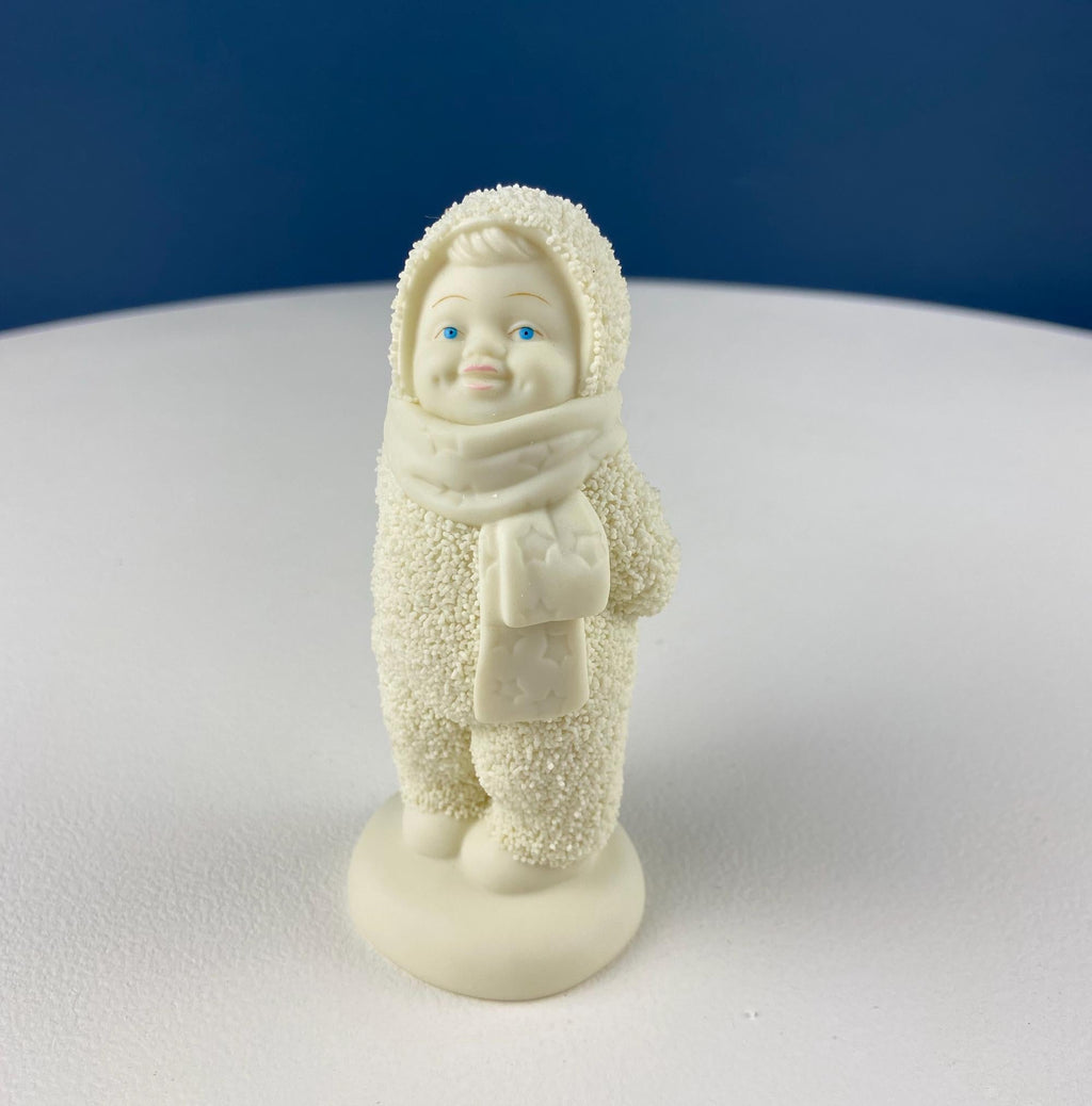 White porcelain snowbaby figurine in hood and scarf holding a small gift