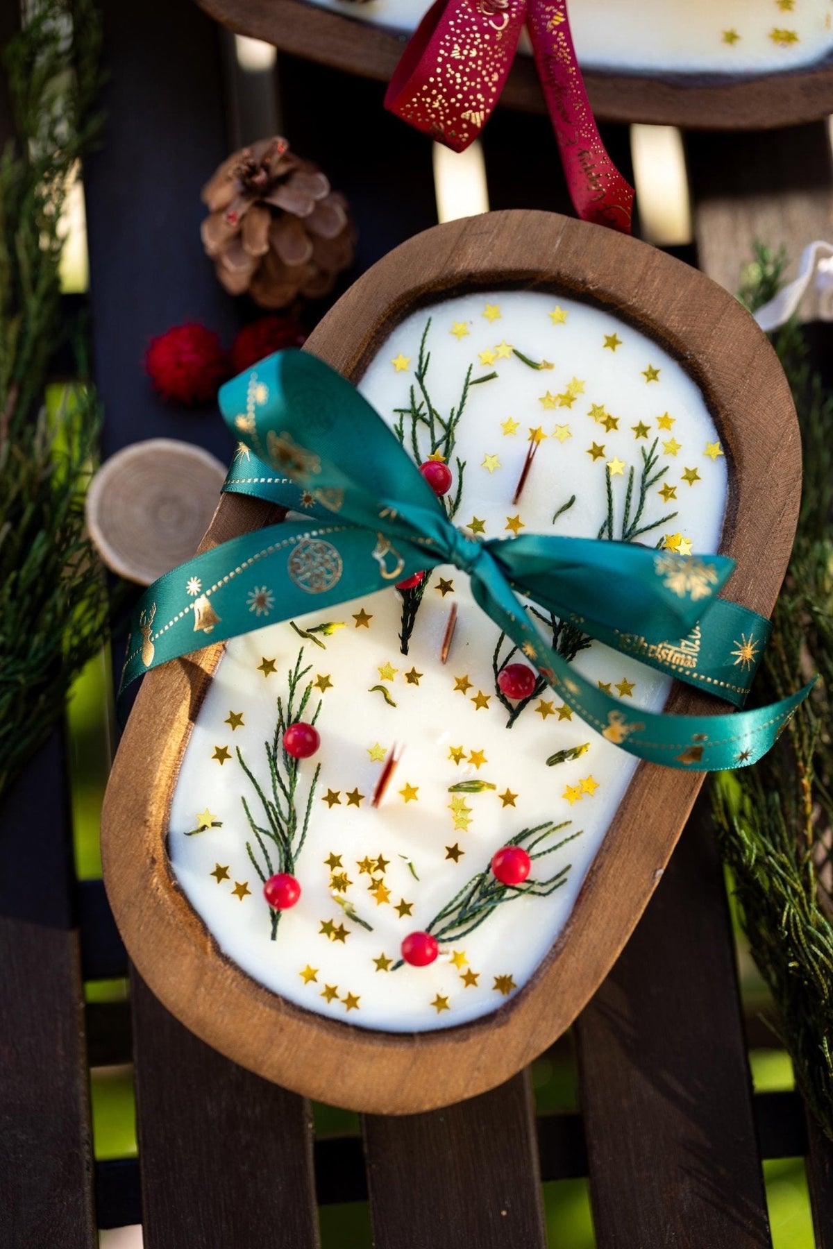 Wood dough bowl candle with white wax holiday sprigs and teal ribbon bow