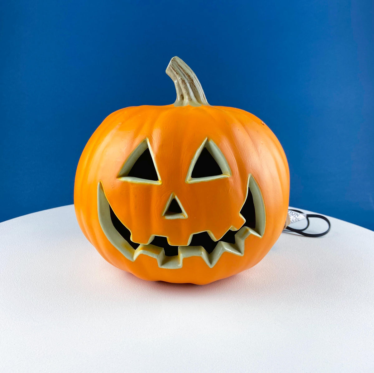 Orange jack-o’-lantern lantern decoration with carved face cutouts