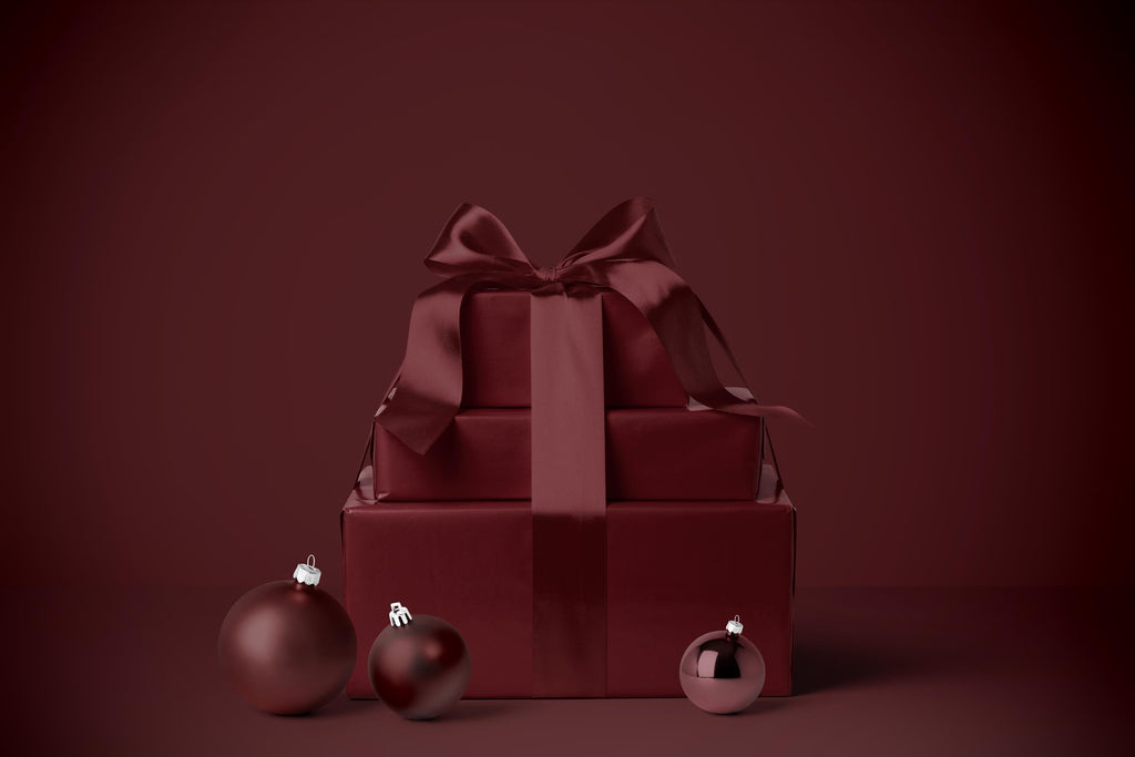 Burgundy gift wrapping paper with satin-style ribbon bow on a wrapped box