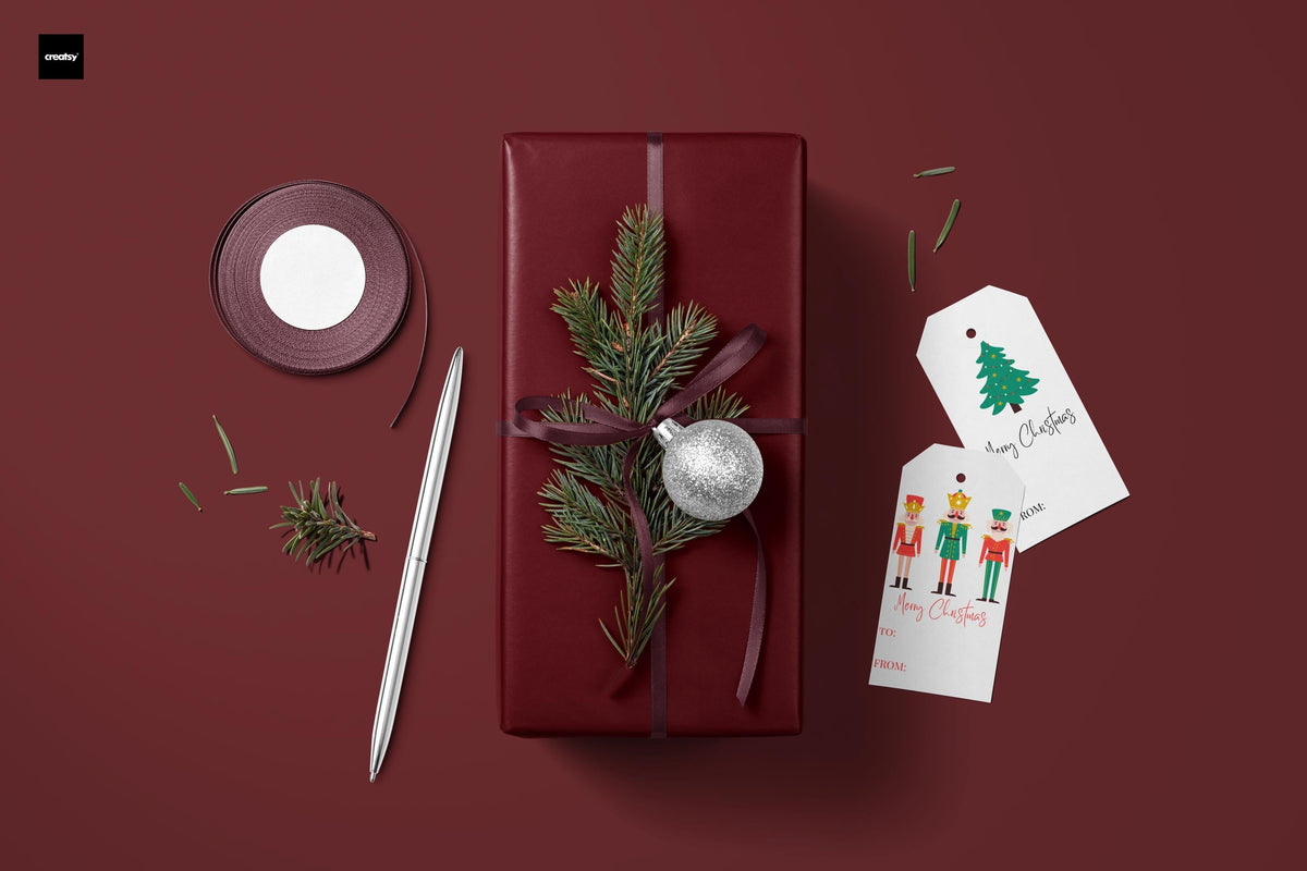 Burgundy wrapping paper bundle with greenery, ornaments, ribbon, and gift tag