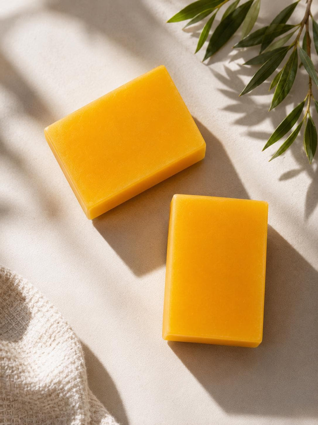 Orange-yellow square soap bars, two bars stacked on a neutral surface