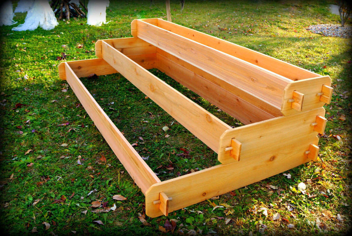 Cedar elevated three-tier raised garden bed planter on grass with slatted boards and corner posts