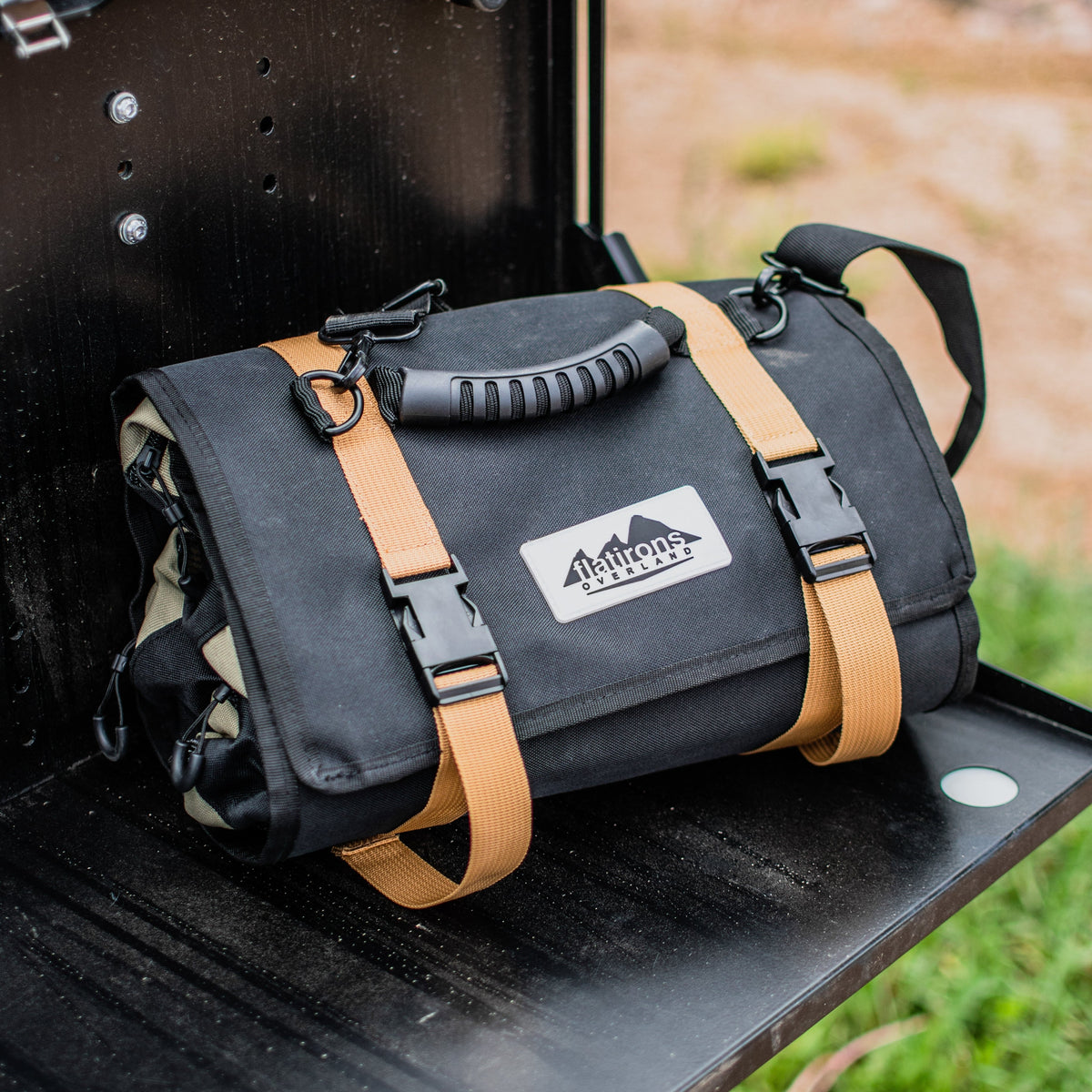 RiPouch Gear Roll on dark surface with tan webbing straps and front logo patch