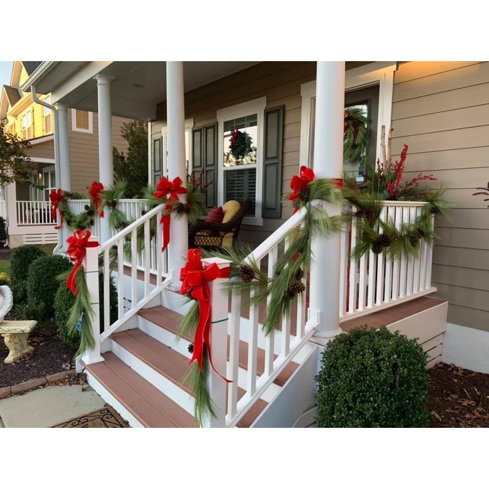 Faux pine garland with pinecones, green needles, and red bow accents