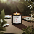 Citronella candle in dark glass jar with white label, flame lit