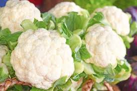 Self-blanching cauliflower heads, pale white with green leaves
