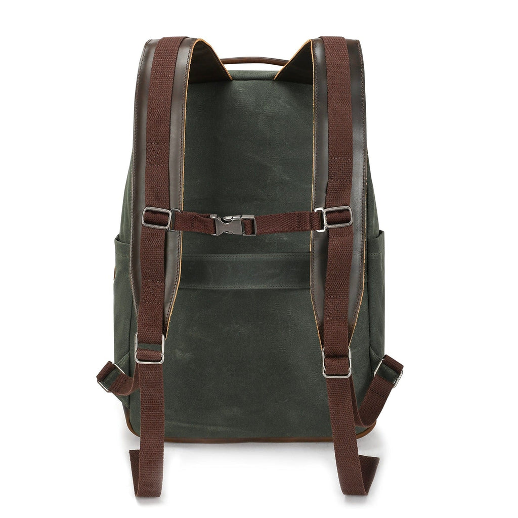 Dark green canvas backpack with brown shoulder straps and front harness-style webbing
