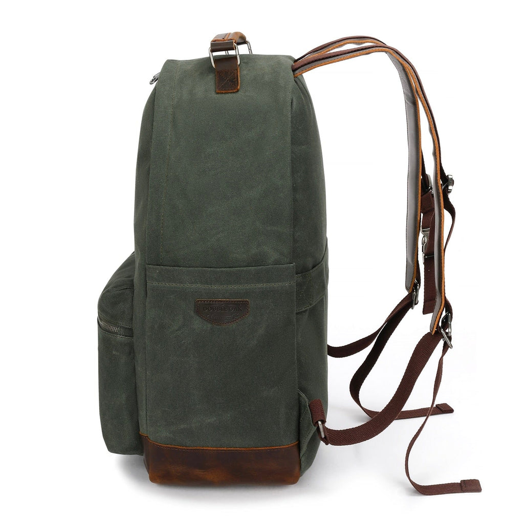 Dark green backpack with top handle, brown trim, and adjustable shoulder straps