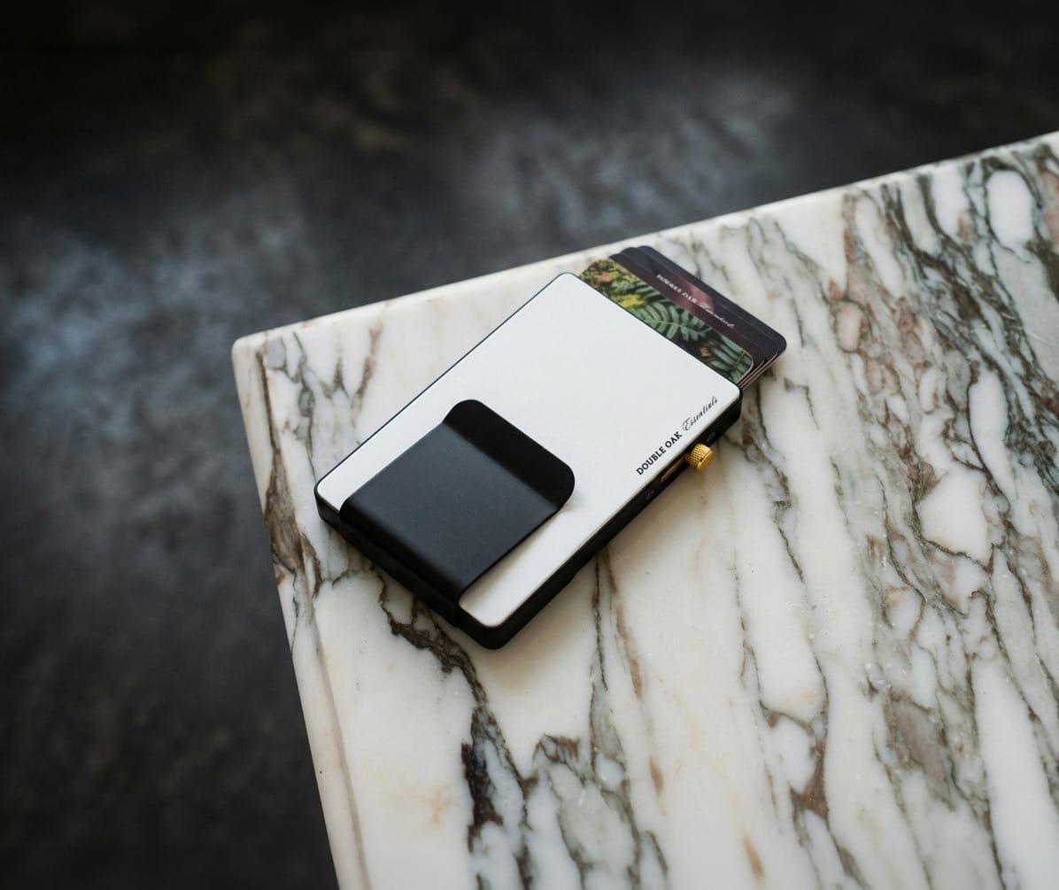 Pop-up cardholder, black front with metal edge, holding cards on marble surface