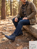 Men's navy work boots with lace-up design and grippy soles, worn with dark jeans