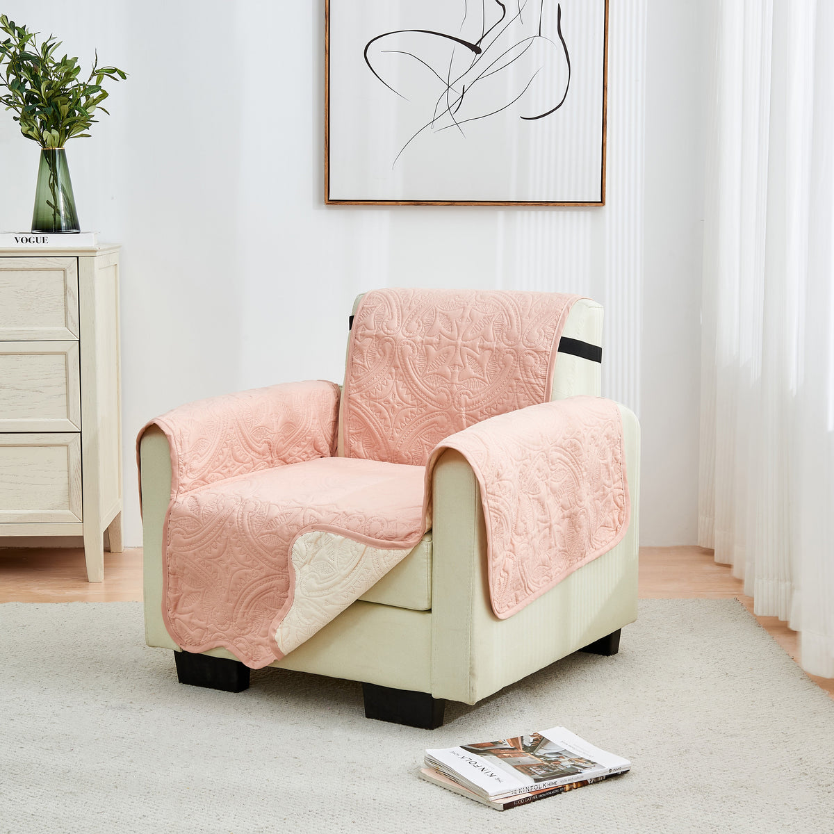Dusty pink loveseat protector cover with quilted medallion pattern, draped over chair