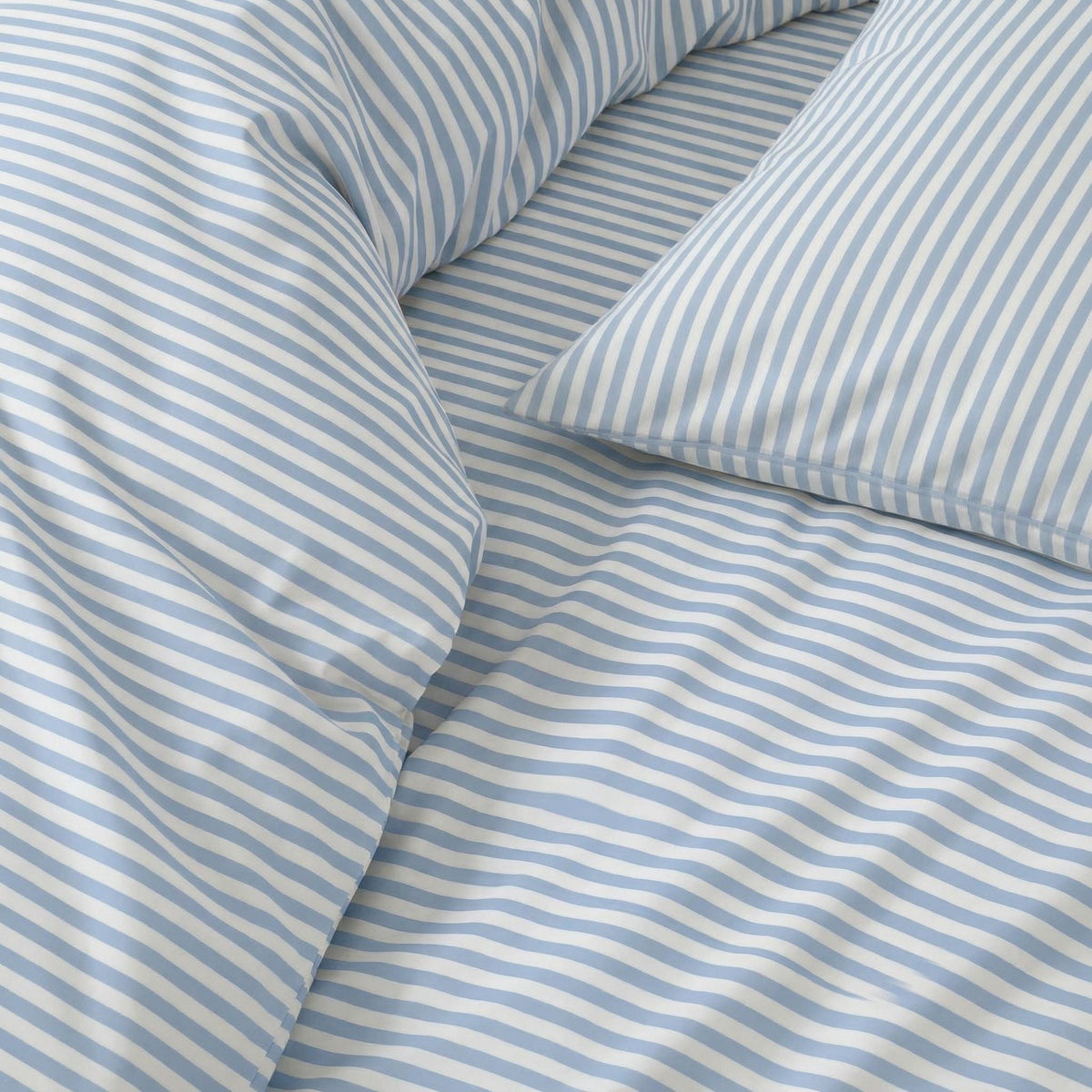 Blue striped sateen bedding bundle close-up of duvet and pillow