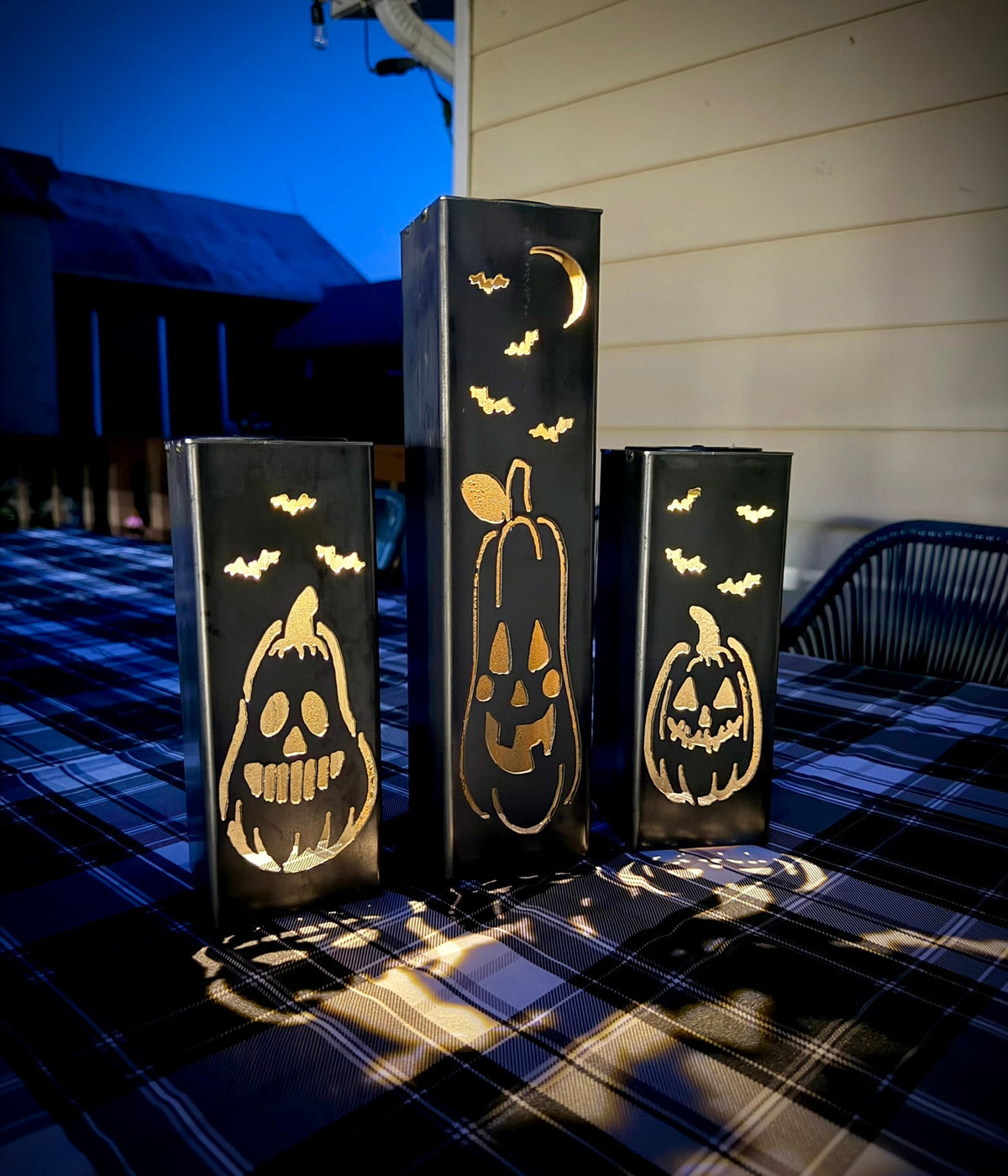 Glowing solar steel tube lights with jack-o-lantern silhouettes on patio