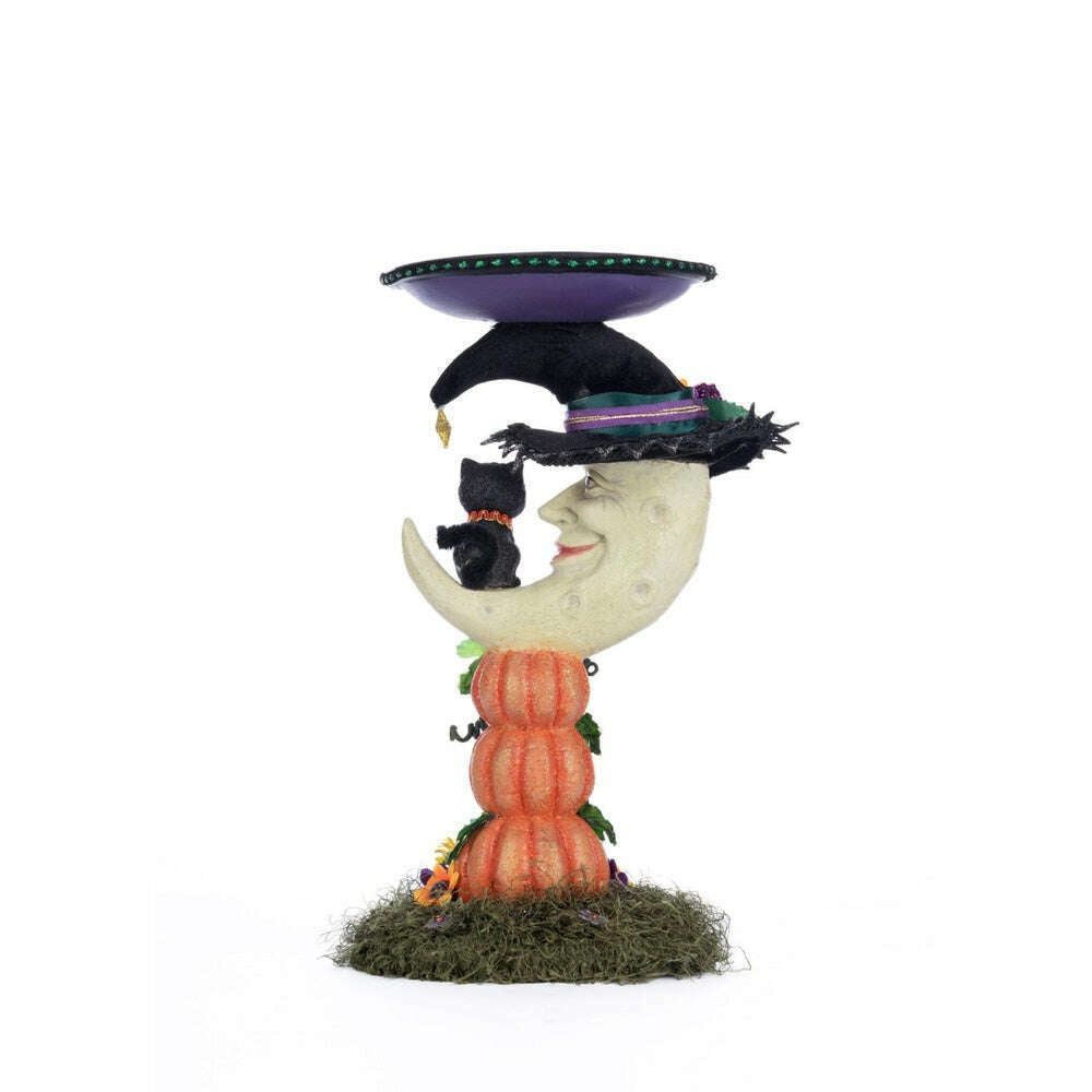 Moon pillar candle holder showing moon face, black graduation cap, and orange pumpkin stack