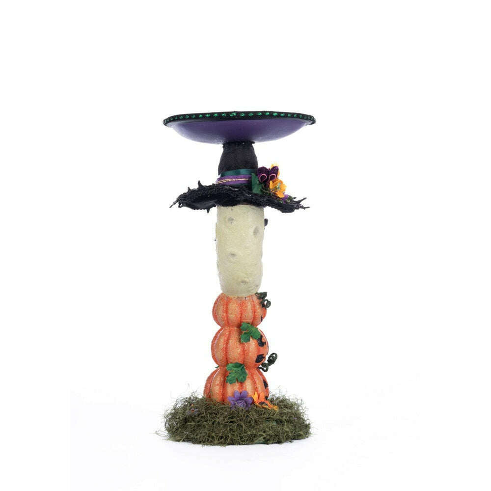 Moon pillar candle holder with purple tray, black cap, and orange pumpkins on grassy base