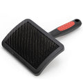 Pet grooming brush with pin bristles on black pad and red-and-black handle