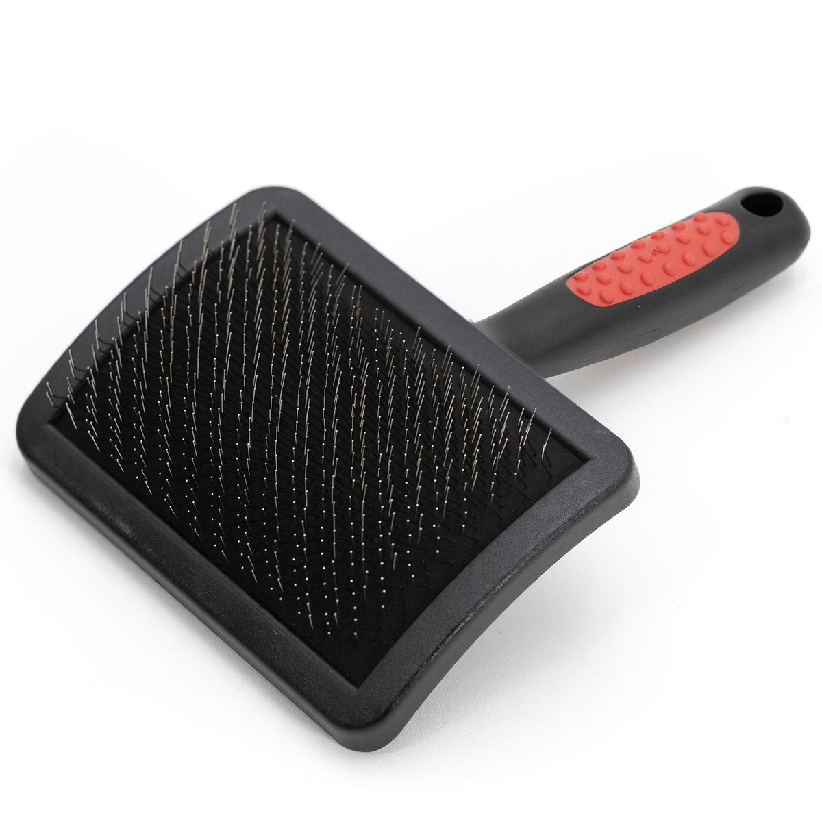 Pet grooming brush with pin bristles on black pad and red-and-black handle