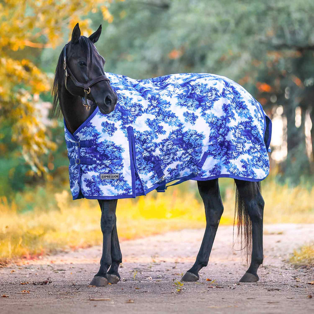 Horse turnout blanket with blue forest-style pattern and adjustable front straps