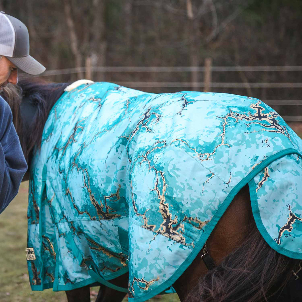 Horse turnout blanket close-up in turquoise with world-map pattern and curved shoulder panel