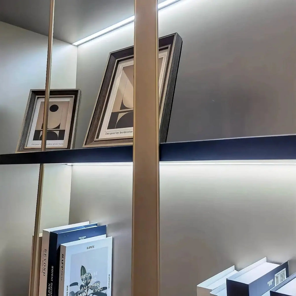Beige shelving unit top shelves with framed decor and LED-lit ledge