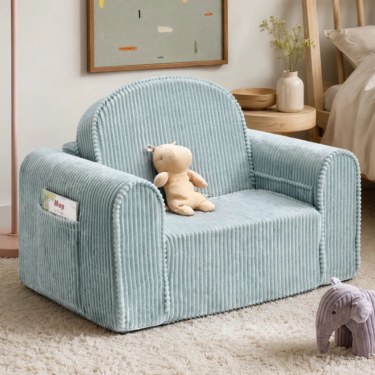 Teal corduroy kids chair with rounded arms and plush cushion, shown with a teddy toy