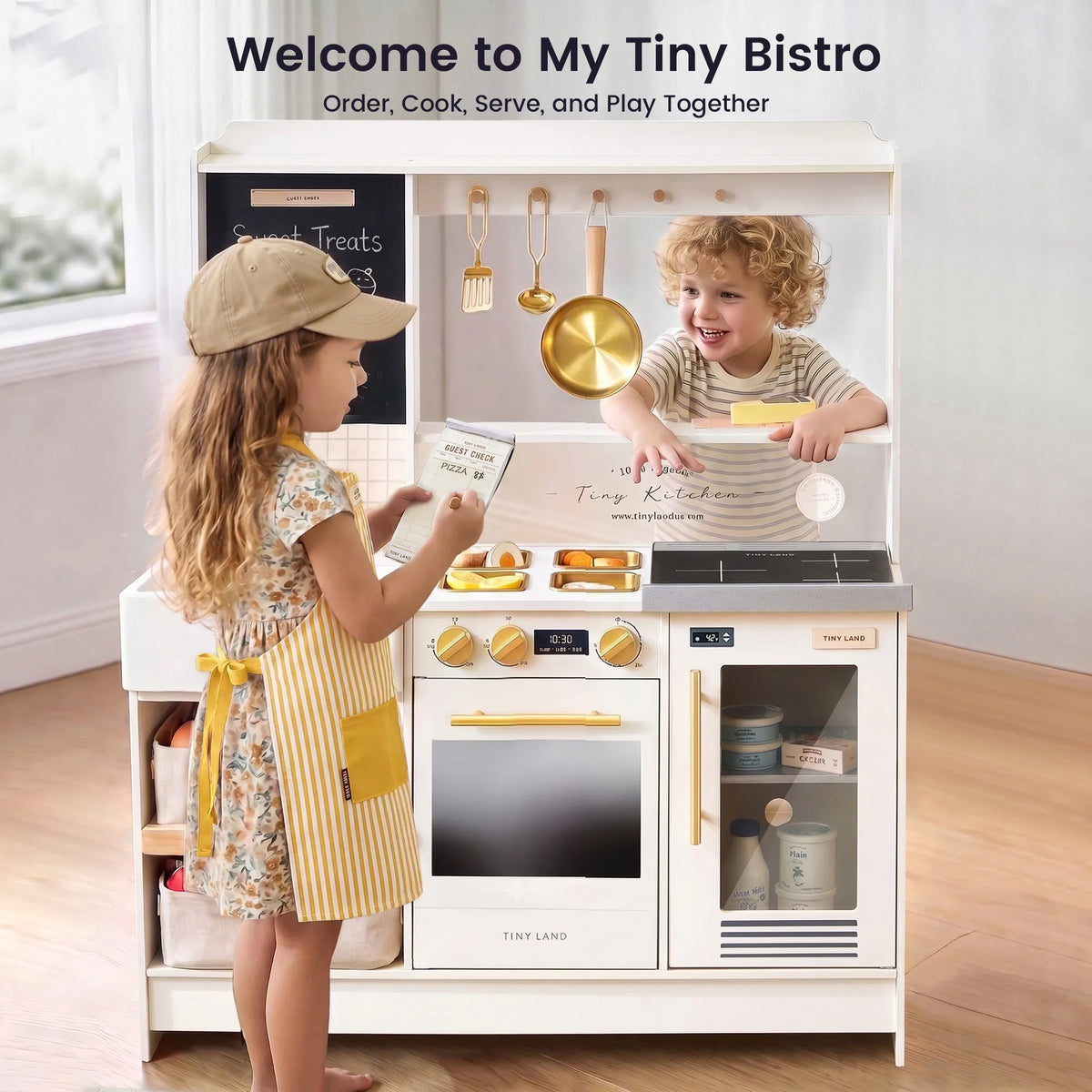 Play bistro kitchen with gold accessories, stovetop, oven, sink, and cabinet doors