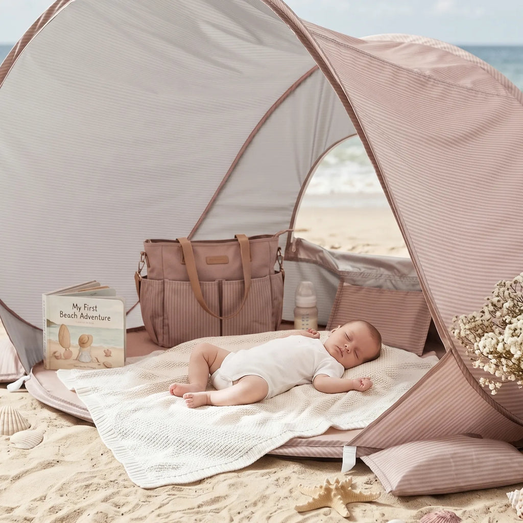 Pink 3-in-1 baby beach tent with open entry and baby lying on bedding