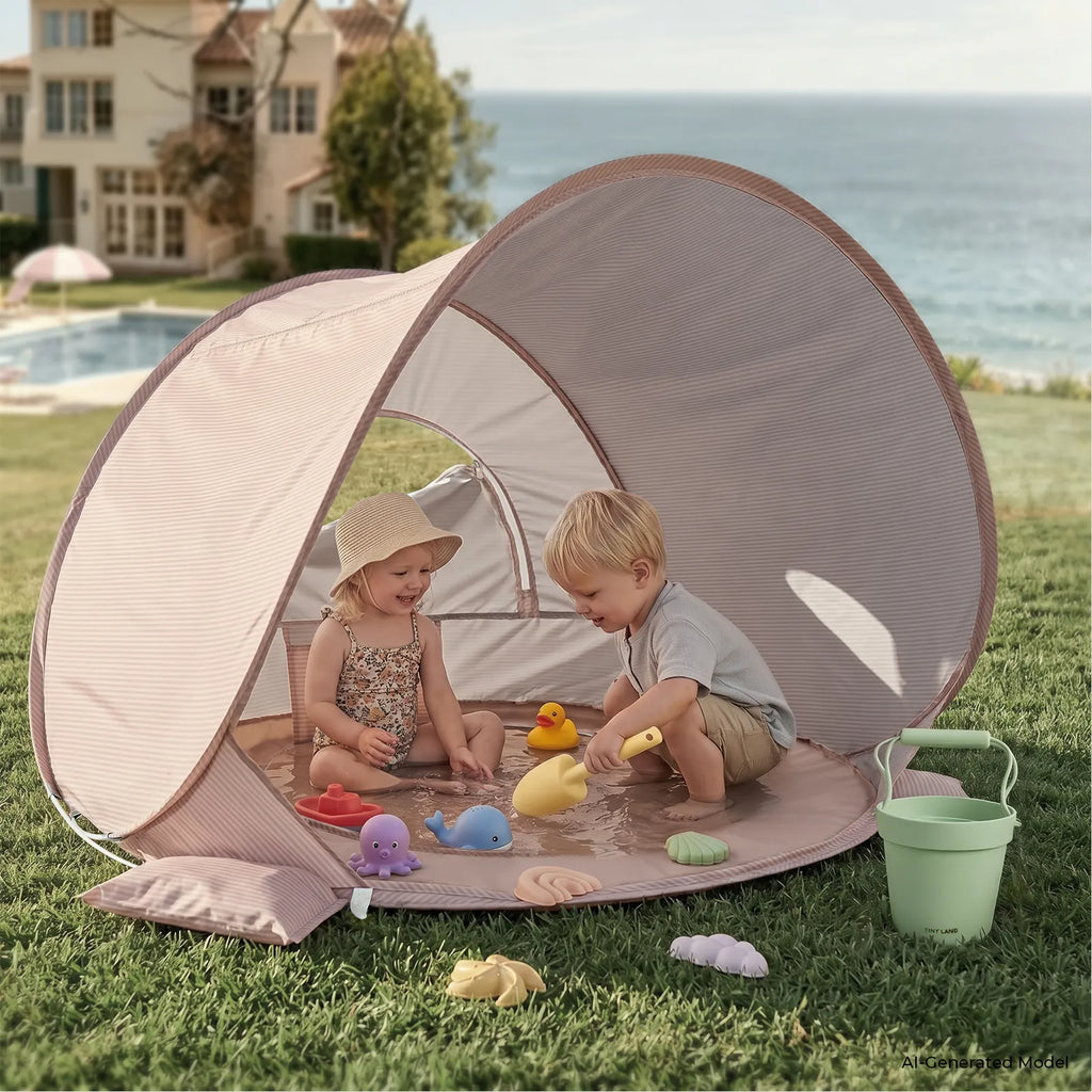 Pink baby beach tent set up on grass with mesh viewing window and arch