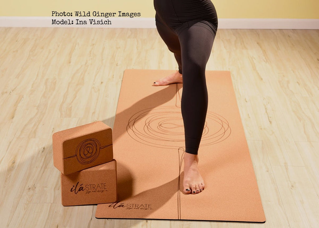 Cork yoga blocks with circular designs beside a matching yoga mat