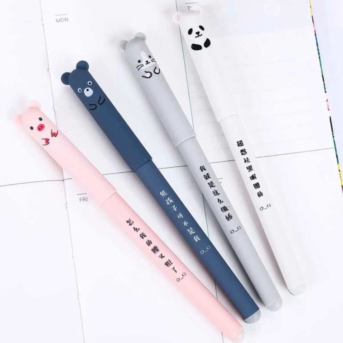 Four animal gel pens in pink, blue, gray, and white on notebook pages