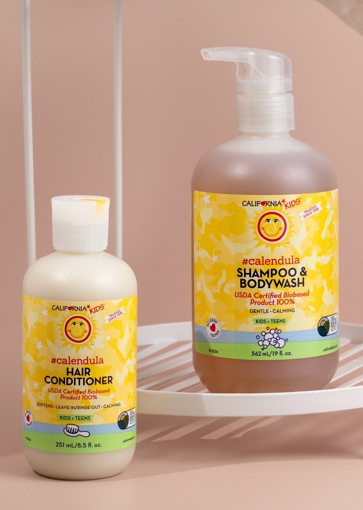 Kids Calendula shampoo & body wash and hair conditioner bottles on shelf, yellow labels