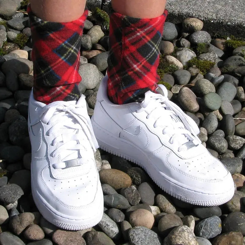 Kids' plaid fleece socks in red and navy shown with white sneakers