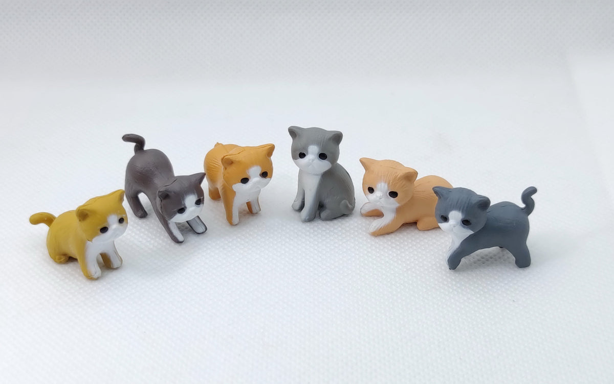 Assorted small cat figurines in gray, tan, and orange colors