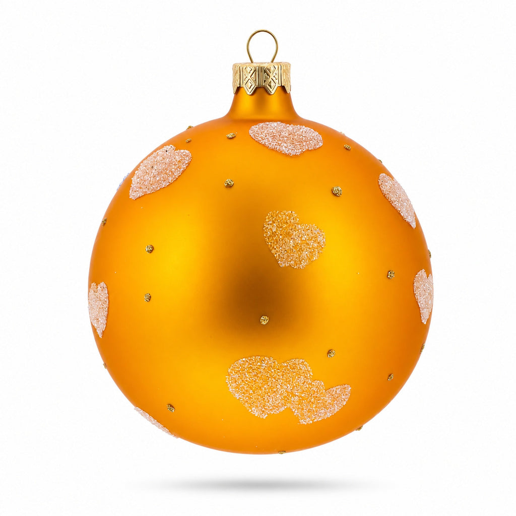 Glass ball Christmas ornament with glitter hearts pattern on orange with hanging loop
