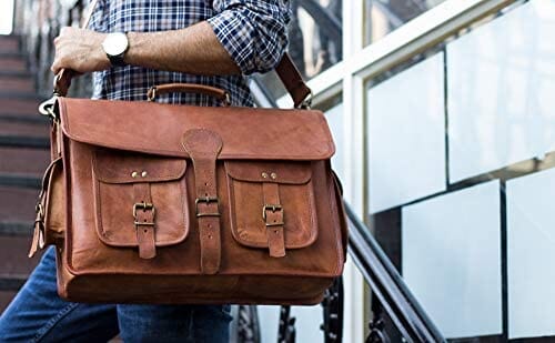Leather briefcase worn over shoulder with flap closure and four front buckle pockets.