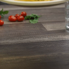 Unbleached paper plate on tabletop with partial view of food