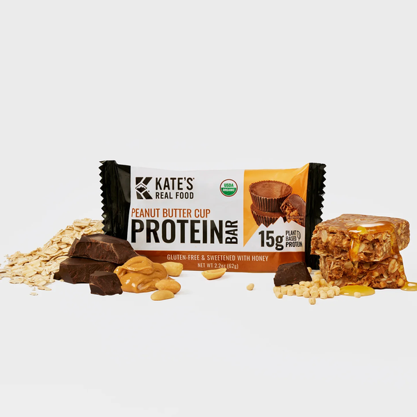 Peanut butter cup protein bar with crumbled pieces and nut bits around the wrapper