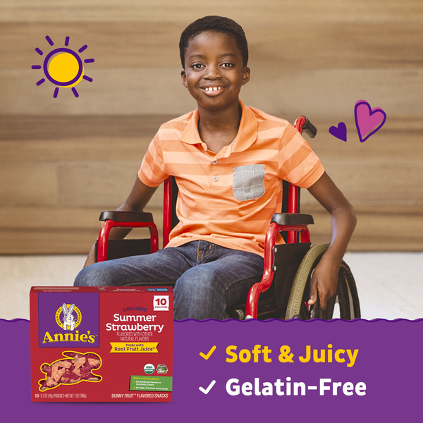 Organic strawberry fruit snack box on a table beside a smiling child