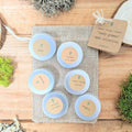 Leafy greens seed collection tins with printed variety labels on a burlap tray