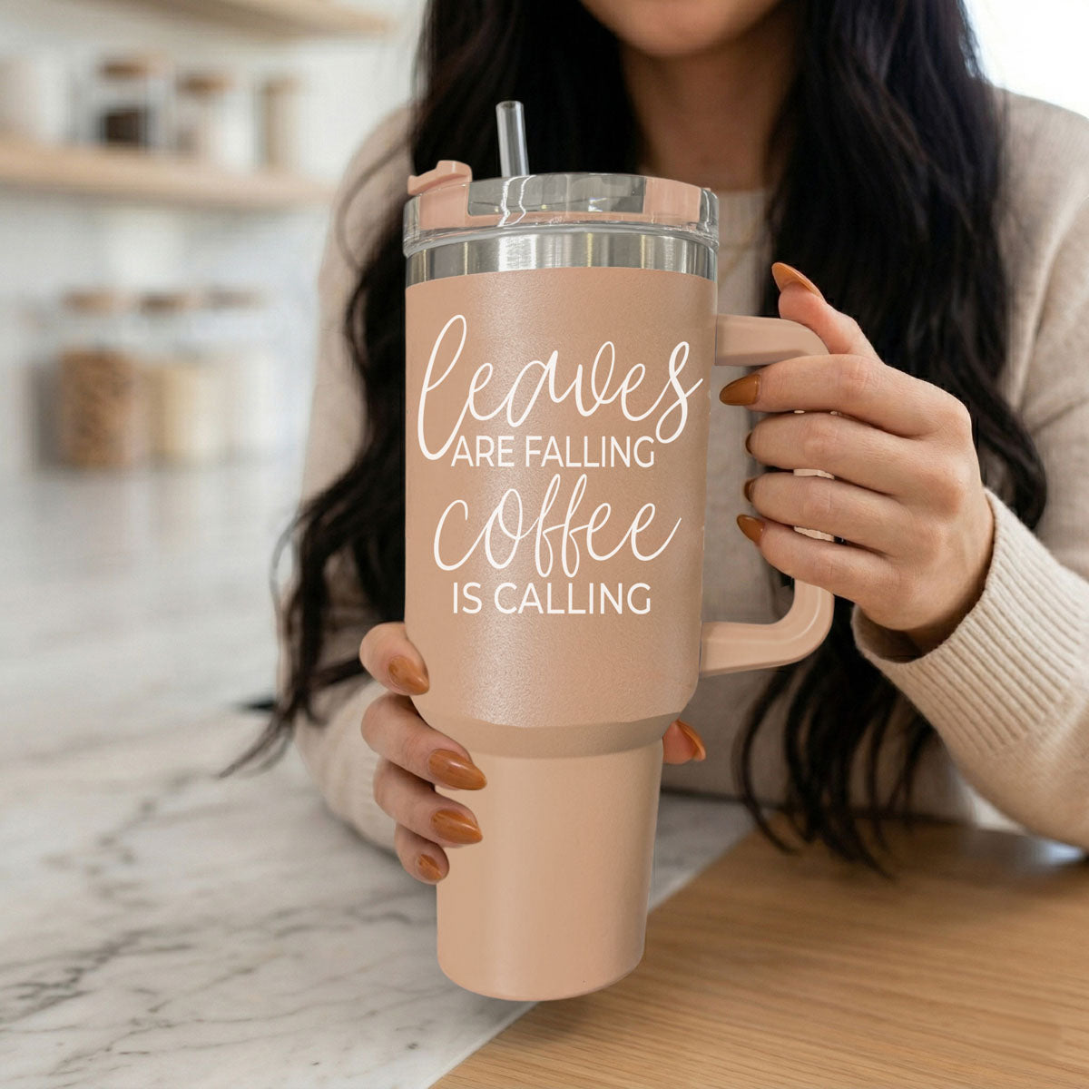Taupe 40oz travel tumbler with clear lid and straw, rose handle, held near face by hands