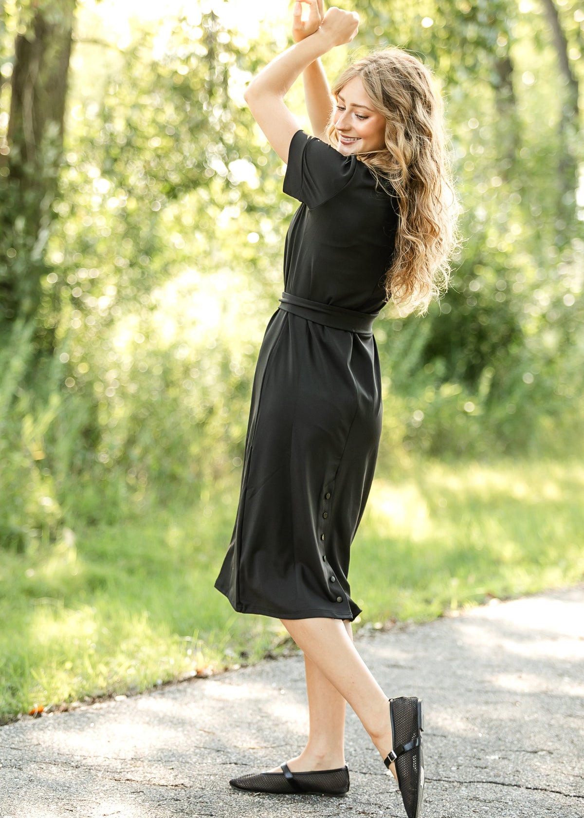 Black midi dress with short sleeves, waist tie belt, and front button detail