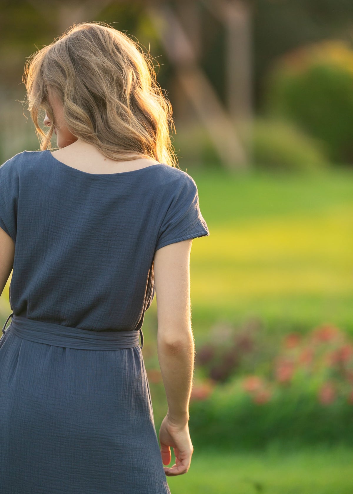 Back view of navy belted midi dress with short sleeves and tied waist