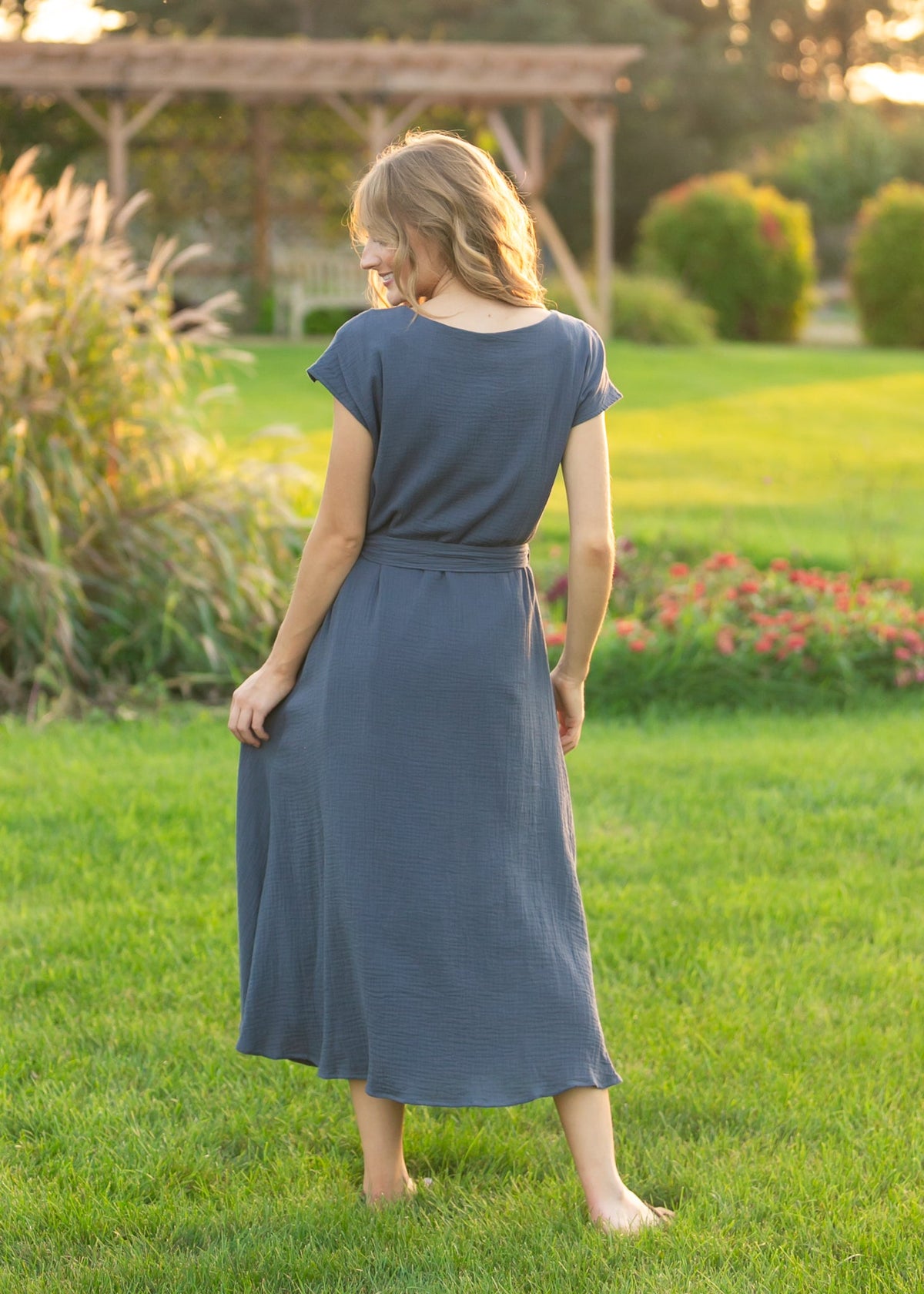 Back view of navy gauze belted midi dress with tie waist and short sleeves